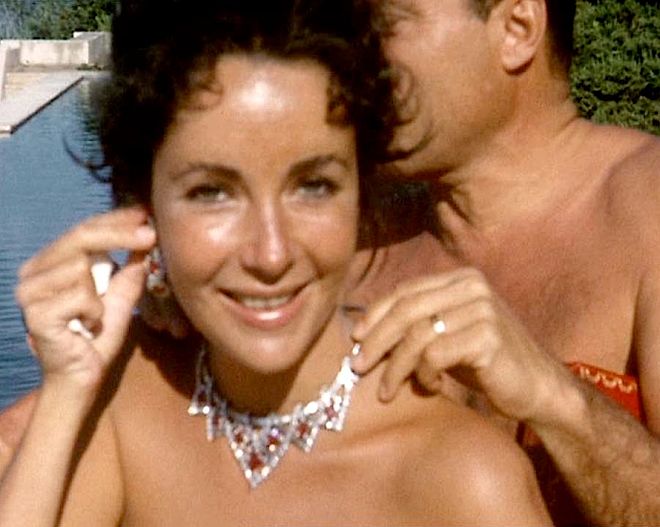 Elizabeth Taylor mierzy rubinowo-diamentowy zestaw biżuterii Cartier, podarowany jej w 1957 roku przez męża Mike'a Todda. Biżuteria Elizabeth Taylor. Najdroższa, jaką kiedykolwiek sprzedano